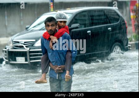 Dhaka. 24th octobre 2022. Les gens marchent dans une rue à eau dans la capitale du Bangladesh Dhaka, le 24 octobre 2022. La plupart des régions du Bangladesh sont témoins de vents violents et de fortes pluies au-dessus du cyclone Sitrang qui se dirige vers la vaste côte du pays d'Asie du Sud. Credit: Xinhua/Alay Live News Banque D'Images