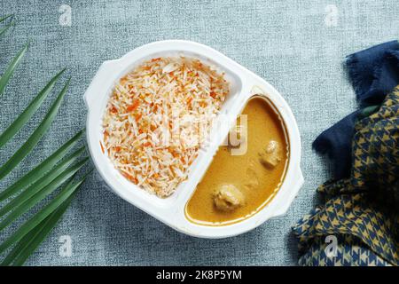 curry de poulet et de riz dans un sachet en plastique à emporter sur la table Banque D'Images