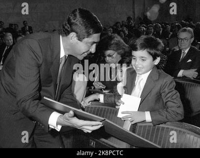 Oslo 19871210 : le Prix de la paix. Le Prix Nobel de la paix 1987 a décerné le prix Nobel de la paix au président du Costa Rica, Oscar Arias Sánchez, pour son travail en faveur de la paix en Amérique centrale. Le Président Arias montre le Prix de la paix à son fils Oscar Felipe après la cérémonie de remise des prix à l'Université Aula. Derrière la mère d'Aria, Lillyan Sanchez et la fille Silvia Eugenia. Photo: Knut Olds Banque D'Images