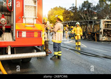 L'équipe de secours des pompiers arrive sur la scène des accidents de la circulation des autobus de passagers à bord d'un accident de voiture. Les pompiers se battent avec le feu sur la route. Accid Banque D'Images