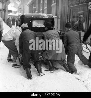 Kralerø 19540320. Le sud de la Norvège est sur le point d'être étranglé par la neige. En février, la neige a renversé jour et nuit pendant 23 jours. Les routes ont été bloquées, les trains ont neigé à l'intérieur, les voitures ont disparu sous les masses de neige, dans de nombreux endroits presque seulement la cheminée coincée au-dessus des maisons. Ici, une voiture a des arrêts de moteur et les gens essaient de s'en aller. Photo: Aage Storløkken / actuel / NTB Banque D'Images