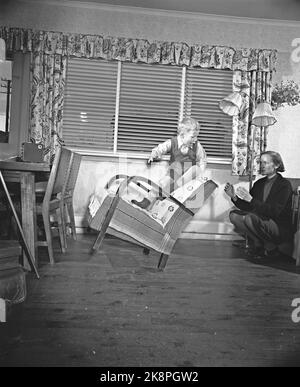 Oslo 19540109 vous êtes en danger où vous allez à la maison est un lieu de travail plus dangereux que beaucoup de femmes au foyer sont au courant. Accidents domestiques, photo d'illustration. Un petit garçon conduit avec un jeu dangereux dans la chaise. La mère essaie de recevoir. Photo: Sverre A. Børretzen / actuel / NTB Banque D'Images