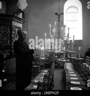 Gran à Hadeland 19600404 après de nombreuses années de restauration, les soi-disant églises sœurs de Granavollen ouvrent leurs portes pour les services de culte. Ici, les intérieurs de la plus grande église (Nicolaikirken) qui sont probablement construits en 1100s. Un des membres du personnel de l'église fait des bougies de cire dans le lustre de l'église. Photo: NTB / NTB Banque D'Images