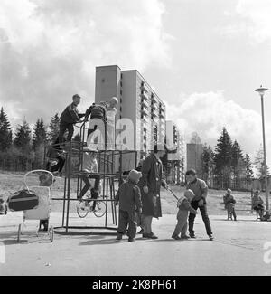 Oslo 19620519: Bøler - Drabantby à Oslo. Blocs hauts. Les enfants jouent dans une aire de jeux. Les mères s'adaptent aux enfants. Rack transparent, harnais d'oie, mode, personnes sur un banc. Mode. La vie quotidienne en 1960s. Enfants dans le harnais. Photo: NTB Banque D'Images