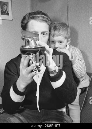 Trondheim 19500204. La star du patinage Hjalmar Andersen 'Hjallis' (27 ans) avec sa famille à Trondheim. Le temps restant après le travail de conducteur de camion et le sport a eu son propre. Les skates ont besoin de soins et de soins qu'ils lui apporteront rapidement sur la glace. Le fils aîné Jan Erik donne de bons conseils sur l'épaule de Dad. Photo: Sverre A. Børresen courant / NTB Banque D'Images