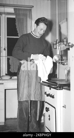 Trondheim 19500204. La star du patinage Hjalmar Andersen 'Hjallis' (27 ans) avec sa famille à Trondheim. Le temps restant après le travail de conducteur de camion et le sport a eu son propre. Ici, nous voyons 'Hjallis' avec un tablier qui prend les plats dans la cuisine. Photo: Sverre A. Børresen courant / NTB Banque D'Images