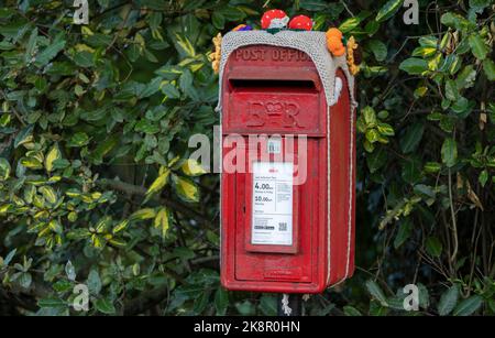 Boîte aux lettres Royal Mail rouge britannique traditionnelle avec décorations sur le dessus, traditions locales Banque D'Images