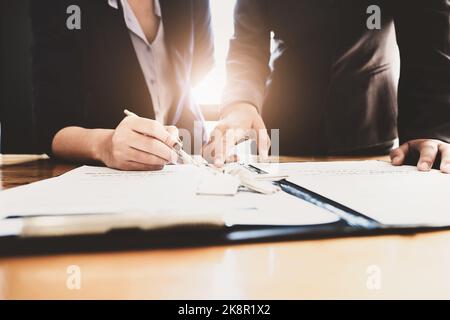 l'agent immobilier donne un accord entre le stylo et les documents avec le client pour signer le contrat. Accord de concept. Banque D'Images