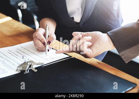 l'agent immobilier donne un accord entre le stylo et les documents avec le client pour signer le contrat. Accord de concept. Banque D'Images
