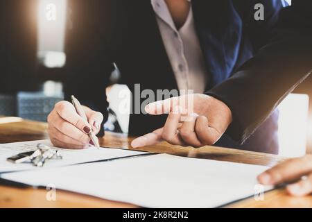 l'agent immobilier donne un accord entre le stylo et les documents avec le client pour signer le contrat. Accord de concept. Banque D'Images