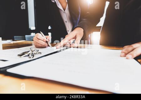l'agent immobilier donne un accord entre le stylo et les documents avec le client pour signer le contrat. Accord de concept. Banque D'Images