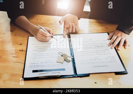 l'agent immobilier donne un accord entre le stylo et les documents avec le client pour signer le contrat. Accord de concept. Banque D'Images