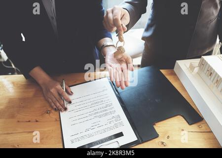 l'agent immobilier donne un accord entre le stylo et les documents avec le client pour signer le contrat. Accord de concept. Banque D'Images