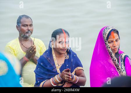 Des hommes et des femmes indiens non identifiés prient et consacrent pour le festival Chhath Puja sur le côté du fleuve Ganges à Varanasi, Inde. Banque D'Images