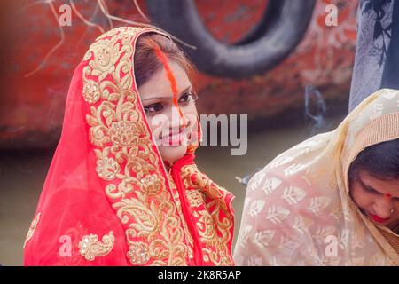 Des hommes et des femmes indiens non identifiés prient et consacrent pour le festival Chhath Puja sur le côté du fleuve Ganges à Varanasi, Inde. Banque D'Images