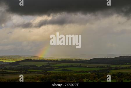 Win Green, Wiltshire, Royaume-Uni, 24th octobre 2022, Météo : un arc-en-ciel se forme à partir de nuages sombres et d'une douche à forte pluie passant au-dessus du paysage de la frontière du Wiltshire Dorset, vu de Win Green, le point le plus élevé sur Cranborne Chase. Paul Biggins/Alamy Live News Banque D'Images