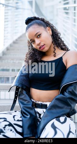 Femme multiraciale assise sur une Stairway moderne en béton dans le centre-ville de San Jose Banque D'Images