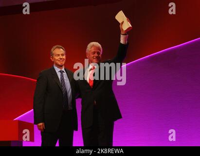 L’ancien président américain Bill Clinton et Tony Blair lors d’une conférence du Parti travailliste à Manchester, au Royaume-Uni, sur fond rouge et violet. Banque D'Images
