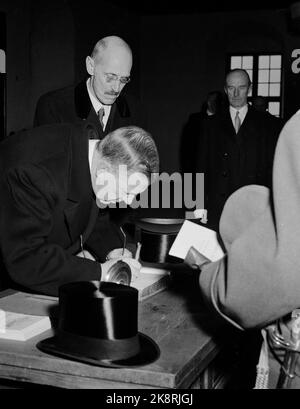Oslo 195203. Le roi Gustaf Adolf et la reine Louise de Suède sont officiellement visités en Norvège. Ici, vous vous rendez au château d'Akershus où le roi Gustaf Adolf écrit son nom dans le livre d'or du château tandis que le roi Haakon attend un voyage. Le chapeau de soie dentaire se trouve sur le bureau. Photo: NTB / NTB Banque D'Images