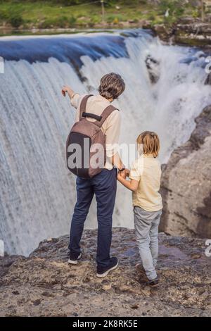 Père et fils touristes sur fond de pittoresques chutes du Niagara sur la rivière Cievna. Monténégro, près de Podgorica. Concept de voyage autour du Monténégro Banque D'Images