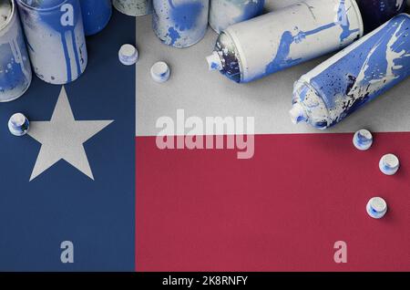 Drapeau de l'État du Texas américain et peu de bombes aérosol utilisées pour la peinture graffiti. Concept de culture d'art de rue, problèmes de vandalisme Banque D'Images