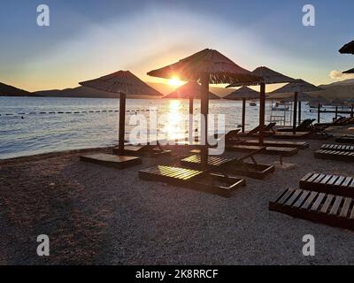 Vue sur les chaises pliantes et les parasols vides sur la rive au coucher du soleil au Monténégro Banque D'Images