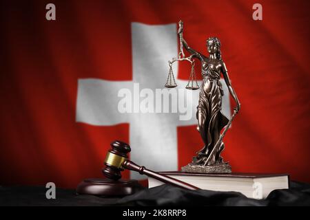 Drapeau suisse avec statue de la justice de dame, constitution et marteau de juge sur la drapererie noire. Concept de jugement et de punition Banque D'Images