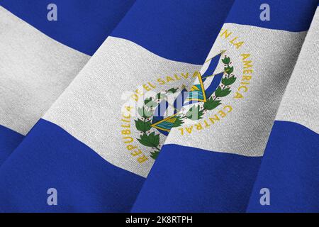 Drapeau El Salvador avec de grands plis et un gros plan sous la lumière du studio à l'intérieur. Les symboles officiels et les couleurs de la bannière en tissu Banque D'Images