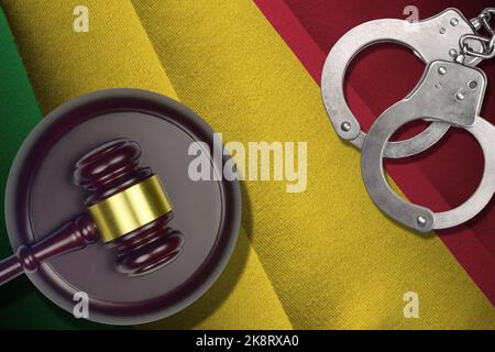 Drapeau du Mali avec maillet de juge et menottes dans la pièce sombre. Concept de criminel et de châtiment, contexte des coupables Banque D'Images