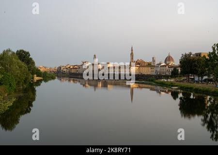 Les bâtiments de la ville se reflétant sur la rivière Arno avec un ciel bleu en arrière-plan, Florence, Italie Banque D'Images