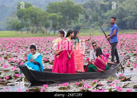 Sylhet, Bangladesh. 24th octobre 2022. 23 octobre 2022, Sylhet, Bangladesh : les visiteurs qui apprécient le bateau pendant la journée découverte à Jaintapur Dibir Hor de Sylhet, tandis que la tempête cyclonique Sitrang provoque de la pluie à Dhaka et dans d'autres parties du pays. Dibir Haor est connu comme Royaume de Shabla pour les voyageurs. Ici, au début du mois bengali d'Hemanta, de nombreuses fleurs rouges de Shabla ont fleuri dans ce Haor qui, sur la rive des collines de Meghalaya. Sur 23 octobre 2022 à Sylhet, Bangladesh. (Photo de MD Rafayat Haque Khan/ Groupe Eyepix/Sipa USA) crédit: SIPA USA/Alay Live News Banque D'Images