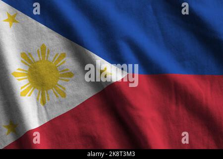 Drapeau des Philippines avec de grands plis et un gros plan sous l'éclairage du studio à l'intérieur. Les symboles officiels et les couleurs de la bannière en tissu Banque D'Images