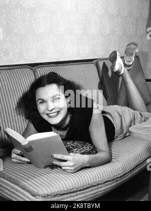 Oslo 19531021. L'acteur Eva Strøm Aastorp vous offre l'amour romantique du succès de l'opéra de Folketateret "les Or diggers" ici nous voyons sa détente à la maison sur le canapé avec un livre. Sourire. Photo: Aage Storløkken / actuel / NTB Banque D'Images