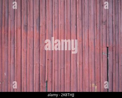 Arrière-plan de planches en bois rouge. Panneaux partiellement cassés et abîmés. Texture d'un bâtiment extérieur d'une vieille maison. Motif de conception vertical. Banque D'Images