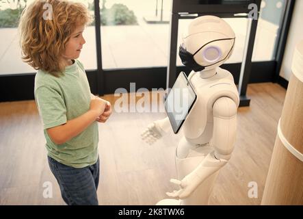 un petit garçon interagit avec l'intelligence artificielle du robot, l'interaction Banque D'Images