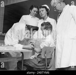 NES à Romerike, 19561016: La première vaccination contre la poliomylitis a commencé à l'école de Framtun à Nes à Romerike. Ruth Hauge, sœur de la santé, vaccine le premier étudiant Ola Eide. Le médecin de district Øverland et les infirmières Borghild Henden et signe Berg suivent. Photo: Aage Storløkken / actuel / NTB Banque D'Images