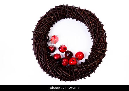 Couronne tissée à partir des branches de la vigne couronne isolée rouge blanc bleu rose brun vigne avec fleurs fruits rowan Banque D'Images