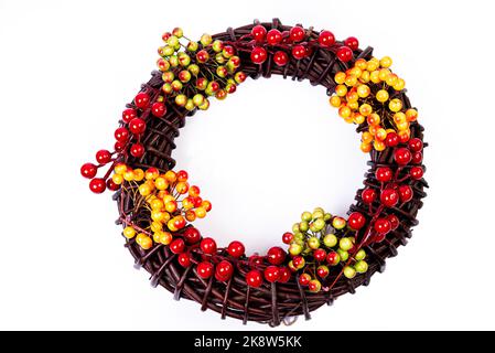 Couronne tissée à partir des branches de la vigne couronne isolée rouge blanc bleu rose brun vigne avec fleurs fruits rowan Banque D'Images
