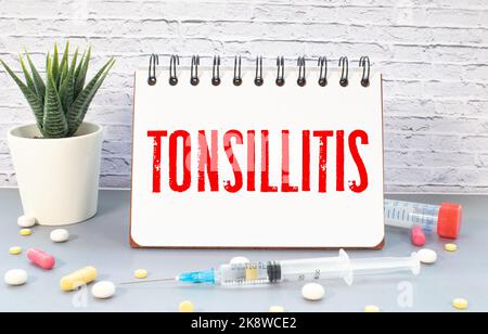 Le médecin garde une carte avec le nom du diagnostic - amygdalite. Mise au point sélective. Concept médical Banque D'Images