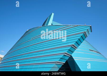 Vue sur la façade en verre bleu et vert en forme de fleur, moderne et incurvée. À la salle de concert du Kazakhstan à Astana, Nursultan, Kazakhstan. Banque D'Images