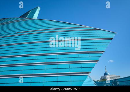 Vue sur la façade en verre bleu et vert en forme de fleur, moderne et incurvée. À la salle de concert du Kazakhstan à Astana, Nursultan, Kazakhstan. Banque D'Images