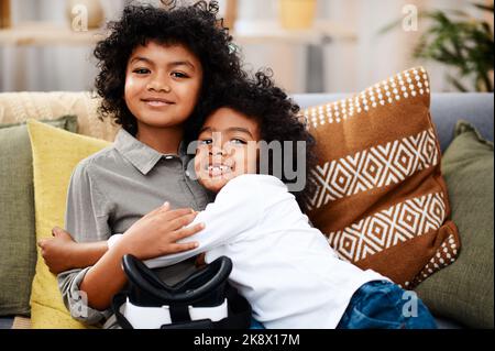 HES le meilleur grand-frère au monde. Portrait de deux adorables petits garçons se embrassant tout en se relaxant sur un canapé à la maison. Banque D'Images