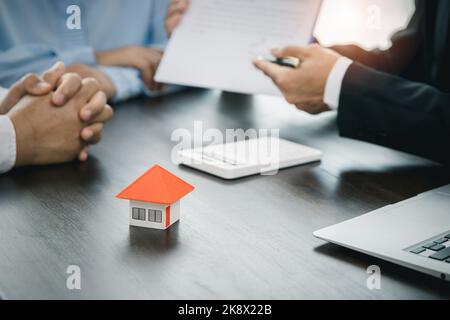 Immobilier. Les acheteurs de maisons se rencontrent et négocient avec les agents immobiliers au sujet de la location ou de l'achat d'une maison dans le bureau. Banque D'Images