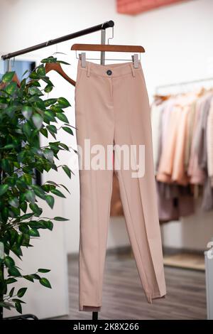 Robes, vestes, pantalons et autres vêtements colorés pour femmes sur cintres dans un magasin de détail. Le concept de mode et de shopping. Vêtements pour femmes Banque D'Images