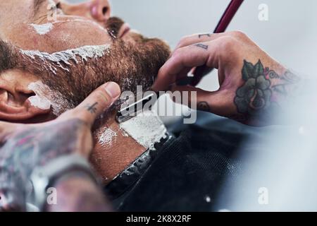 À la barbe ou pas à la barbe. Un homme méconnaissable qui tond sa barbe et l'alignait dans un salon de coiffure. Banque D'Images