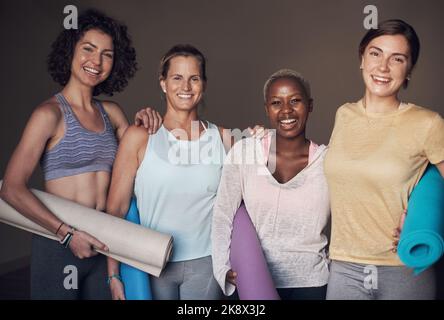 Nous courons, nous ne cassons pas. Portrait court d'un jeune groupe de femmes assis ensemble et solidaires au cours d'une séance de yoga à l'intérieur. Banque D'Images