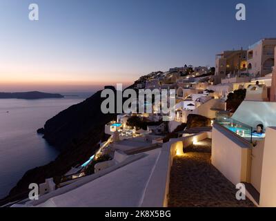 Coucher de soleil de Fira avec des hôtels de charme et des piscines et Skaros Rock en arrière-plan, sur l'île grecque des Cyclades de la mer Égée de Santorin. Banque D'Images