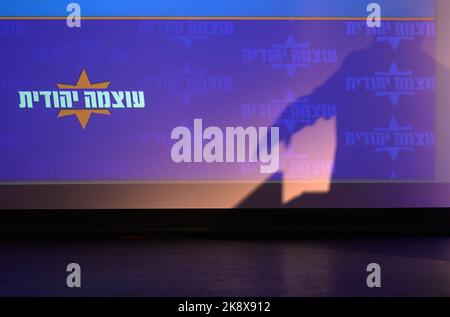 Le législateur d'extrême-droite Itamar Ben-Gvir, jette une ombre sur le logo du parti Otzma Yehudit (puissance juive), en s'advenant à ses partisans lors d'une campagne électorale dans un centre culturel de 23 octobre 2022 à tel-Aviv, Israël. Les sondages d’opinion montrent un soutien significatif au parti sionisme religieux qui s’est associé à la puissance juive d’extrême-droite, en prévision des élections parlementaires prévues pour l’1 novembre Banque D'Images