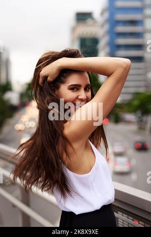 Ce point de vue me fait me sentir si vivant. Portrait court d'une jeune femme attrayante souriant sur un balcon de la ville. Banque D'Images