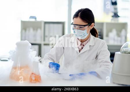 Regardez cette réaction chimique. Un jeune scientifique faisant une expérience dans un laboratoire. Banque D'Images